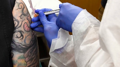 Melissa Harting, of Harpersville, N.Y., receives an injection as a study of a possible COVID-19 vaccine developed by the National Institutes of Health and Moderna Inc., Binghamton, N.Y., July 27, 2020.