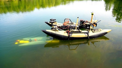 A yellow underwater robot finds its way to a mobile docking station to recharge and upload data before continuing a task.