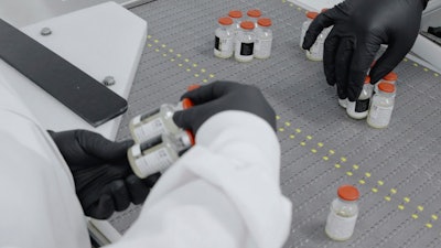 An undated image from video provided by Regeneron Pharmaceuticals shows vials inspected at the company's facilities in New York state, Oct. 2, 2020.