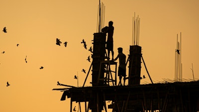 Laborers work at a building construction site in Gauhati, India, Oct. 19, 2020.