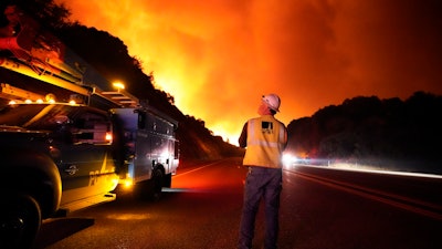 A Pacific Gas and Electric worker looks up at the advancing Creek Fire along Highway 168 near Alder Springs, Calif., Sept. 8, 2020.