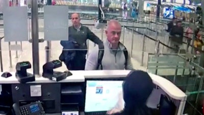 Image from security camera video showing Michael L. Taylor, center, and George-Antoine Zayek at passport control at Istanbul Airport in Turkey, Dec. 30, 2019.