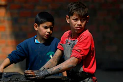 Mauri, 11, left, and Cesar, 13, work at a clay brick factory in Tobati, Paraguay, Friday, Sept. 4, 2020. The boys have been working at the factory, run by Mauri's family, since before schools stopped operating in March amid the COVID-19 pandemic.