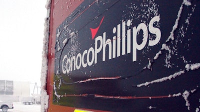 This Feb. 9, 2016, file photo shows an ice-covered ConocoPhillips sign at a drilling site in Nuiqsut, Alaska. ConocoPhillips is buying shale producer Concho Resources in an all-stock deal valued at $9.7 billion. The companies said Monday, Oct. 19, 2020, that the combined business will be the largest independent oil and gas company, with pro forma production of more than 1.5 million barrels of oil equivalent per day.