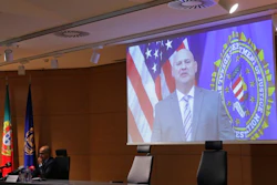 FBI Pittsburgh Special Agent Michael Christman speaks in a video presented by Portuguese police chief inspector Paulo Goncalves, at left, during a news conference at the police headquarters in Lisbon, Thursday, Oct. 15, 2020. European and American officials say that they have arrested 20 individuals for allegedly belonging to an international ring that laundered millions of euros stolen by cybercriminals in an international police operation led by Portuguese investigators and the F.B.I.