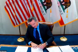 In this Wednesday, Sept. 30, 2020 file image made from video from the Office of the Governor, California Gov. Gavin Newsom signs into law a bill that establishes a task force to come up with recommendations on how to give reparations to Black Americans in Sacramento, Calif. A conservative legal group announced Monday, Oct. 5 that it sued to block California's first-in-the-nation law that requires hundreds of corporations based in the state to have directors from racial or sexual minorities on their boards.
