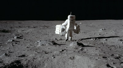 Lunar module pilot Buzz Aldrin carries a seismic experiments package and the Laser Ranging Retroreflector to the deployment area at Tranquility Base, July 20, 1969.