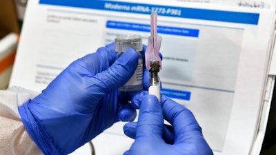 Nurse Kathe Olmstead prepares a shot for part of a possible COVID-19 vaccine, Binghamton, N.Y., July 27, 2020.