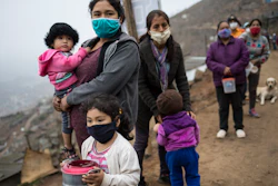 People line up for a free meal in the Villa Maria del Triunfo district in Lima, Peru, June 17, 2020.