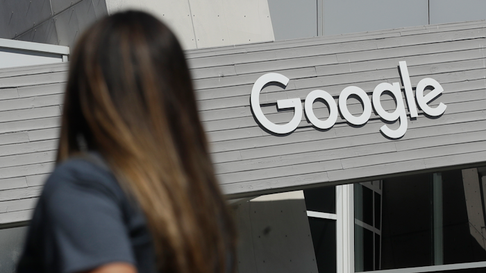 In this Sept. 24, 2019, file photo a woman walks below a Google sign on the campus in Mountain View, Calif. In the years since Barack Obama and Joe Biden left the White House, the tech industry's political fortunes have flipped. Facebook, Google, Amazon and Apple have come under scrutiny from Congress, federal regulators, state attorneys general and European authorities.