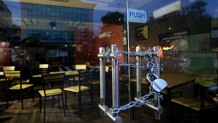 The entrance of an eatery is locked after it closed down due to pandemic in Bengaluru, India, Oct. 11, 2020.