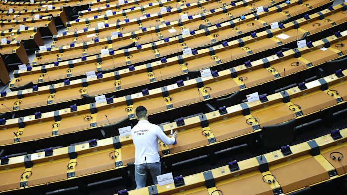A worker sanitizes desks at the European Parliament in Brussels, Sept. 16, 2020.