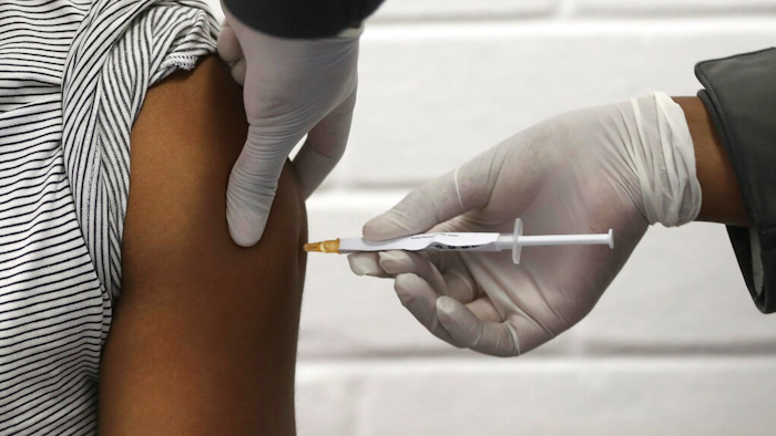 In this Wednesday, June 24, 2020 file photo, a volunteer receives an injection at the Chris Hani Baragwanath hospital in Soweto, Johannesburg, as part of Africa's first participation in a COVID-19 vaccine trial developed at the University of Oxford in Britain in conjunction with the pharmaceutical company AstraZeneca. On Friday, Oct. 23, 2020, AstraZeneca Inc. announced that the Food and Drug Administration is letting it resume testing of its COVID-19 vaccine candidate in the U.S.
