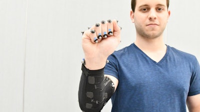 Moritz Graule, a graduate student at SEAS, demonstrates a fabric arm sleeve with embedded sensors.