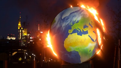 A makeshift globe burns in front of the European Central Bank in Frankfurt, Germany, Oct. 21, 2020.