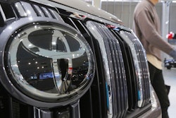 A visitor walks by a Toyota car displayed at a Toyota Motor Corp. showroom.