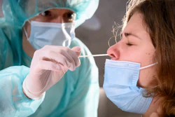 A health worker collects a nose swab sample for a polymerase chain reaction test at the Mycorama coronavirus testing facility, Cernier, Switzerland, Nov. 3, 2020.