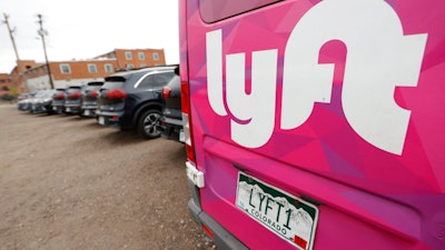 Kia Neros that are part of the Lyft ride-hailing fleet sit in a lot near Empower Field at Mile High in Denver, April 30, 2020.