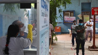 A health worker takes a nasal swab sample at a COVID-19 testing center in Hyderabad, India, Nov. 12, 2020.