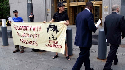 Protesters stand in front of the federal courthouse during the arraignment of hacker Jeremy Hammond, New York, May 14, 2012.