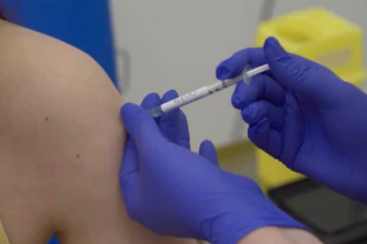 A person being injected as part of the first human trials in the UK to test a potential coronavirus vaccine, April 23, 2020.