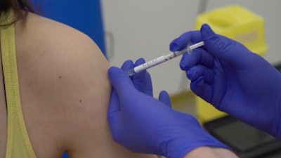 A person being injected as part of the first human trials in the UK to test a potential coronavirus vaccine.