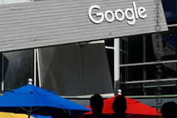 People walk by a Google sign on its campus in Mountain View, Calif., Sept. 24, 2019.