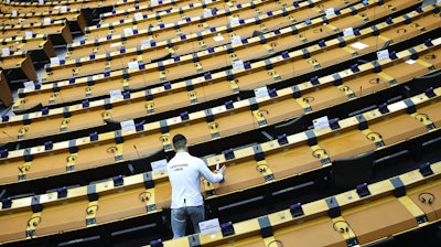 A worker sanitizes desks at the European Parliament in Brussels, Sept. 16, 2020.