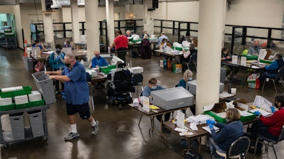 Election workers organize ballots at the Multnomah County Elections Division, Portland, Ore., Nov. 3, 2020.