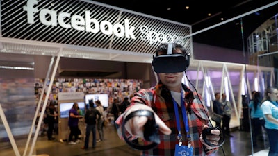 An attendee at Facebook's developer conference tries on Oculus Go goggles, San Jose, Calif., May 1, 2018.