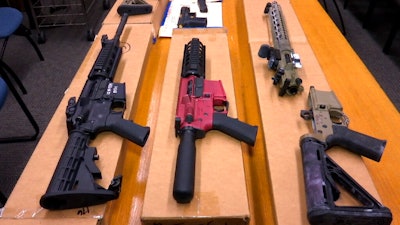 This Nov. 27, 2019, file photo shows 'ghost guns' on display at the headquarters of the San Francisco Police Department in San Francisco. Families of those killed and wounded in a rural California shooting rampage in 2017 are suing manufacturers and sellers of 'ghost gun' kits that provide easy-to-assemble firearm parts that make it difficult to track or regulate owners.