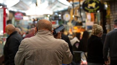 A man speaks on his mobile phone in the Mahane Yehuda market in Jerusalem, Dec. 23, 2020.