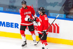 Canada's Braden Schneider (2) and Philip Tomasino (26) celebrate a goal against Switzerland during the first period of an IIHF World Junior Hockey Championship game in Edmonton, Alberta, Dec. 29, 2020.