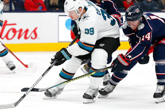 The San Jose Sharks' Logan Couture skates the puck up ice as Columbus Blue Jackets' Gustav Nyquist defends during a game in Columbus, Ohio, Jan. 4, 2020.