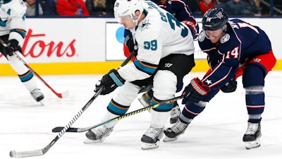 The San Jose Sharks' Logan Couture skates the puck up ice as Columbus Blue Jackets' Gustav Nyquist defends during a game in Columbus, Ohio, Jan. 4, 2020.