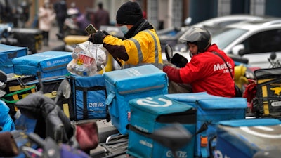 A food delivery worker outside a restaurant in Beijing, Jan. 14, 2021.