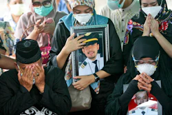 Relatives pray during the burial of Fadly Satrianto, a victim of the crash of Sriwijaya Air flight SJ-182, Surabaya, East Java, Indonesia, Jan. 15, 2021.