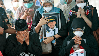 Relatives pray during the burial of Fadly Satrianto, a victim of the crash of Sriwijaya Air flight SJ-182, Surabaya, East Java, Indonesia, Jan. 15, 2021.