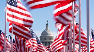 The U.S. Capitol is seen between flags placed on the National Mall ahead of the inauguration of President-elect Joe Biden and Vice President-elect Kamala Harris, Washington, Jan. 18, 2021.