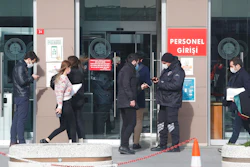 A security official checks people's IDs before the third hearing in the trial of Carlos Ghosn, Istanbul, Jan. 20, 2021.