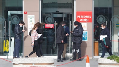 A security official checks people's IDs before the third hearing in the trial of Carlos Ghosn, Istanbul, Jan. 20, 2021.