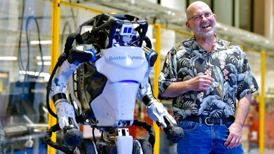 Marc Raibert, founder and chair of Boston Dynamics, stands beside one of the company's Atlas robots at its facilities in Waltham, Mass., Jan. 13, 2021.