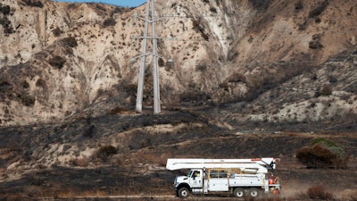SoCal Edison trucks arrive at the site of a transformer tower in Sylmar, Calif., suspected of being responsible for the Saddleridge fire, Oct. 15, 2019.