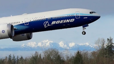 In this file photo a Boeing 777X airplane takes off on its first flight. Boeing is reporting another huge loss, this one because of a setback to its 777X widebody jetliner.