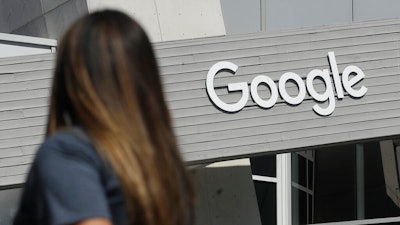 In this Sept. 24, 2019, file photo a woman walks below a Google sign on the company's campus in Mountain View, Calif. A group of Google engineers announced Monday, Jan. 4, 2021, they have formed a union, creating a rare foothold for the labor movement in the tech industry.