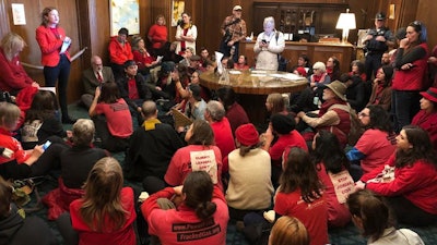 Demonstrators against a proposed liquid-natural gas pipeline and export terminal sit in in the governor's office, Salem, Ore., Nov. 21, 2019.