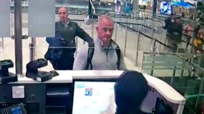 Image from security camera video showing Michael L. Taylor, center, and George-Antoine Zayek at passport control, Istanbul Airport, Dec. 30, 2019.