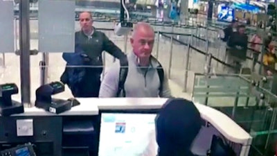 Image from security camera video showing Michael L. Taylor, center, and George-Antoine Zayek at passport control at Istanbul Airport, Dec. 30, 2019.