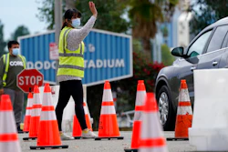 Cars are waved in as people arrive to receive the COVID-19 vaccine at Dodger Stadium, Los Angeles, Feb. 1, 2021.