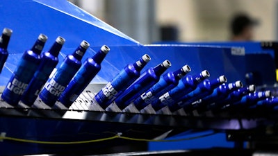 In this April 8, 2016, file photo, aluminum Bud Light bottles move along a conveyor at a plant manufacturing 16-ounce Budweiser and Bud Light aluminum bottles for Anheuser-Busch, in Arnold, MO.